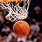 A basketball drops from the net during a game in an arena