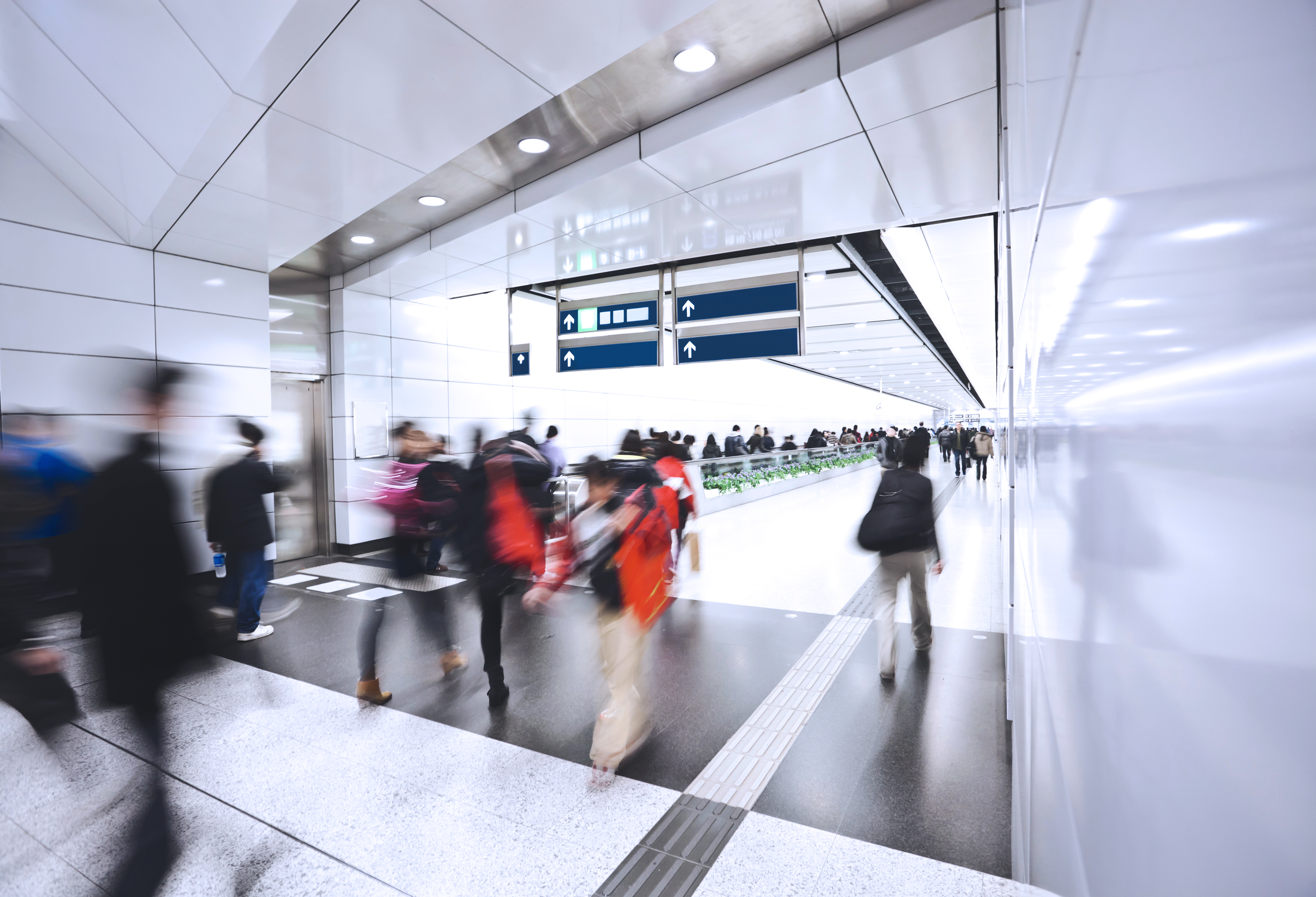 People walking through a clean, modern subway station. 