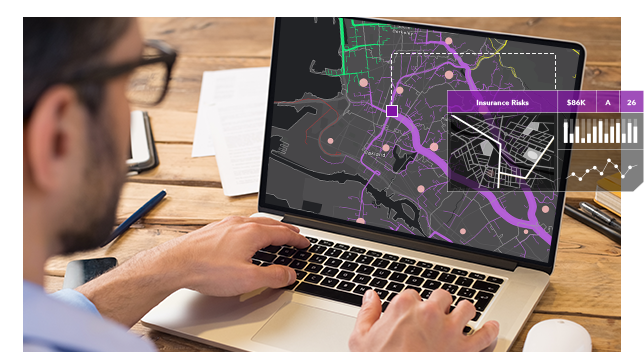 A person wearing glasses sitting at a table using a laptop displaying a map overlaid with a transparent analytics window