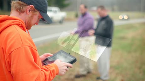 Un hombre utiliza una tablet para analizar las tendencias de los datos en un mapa.