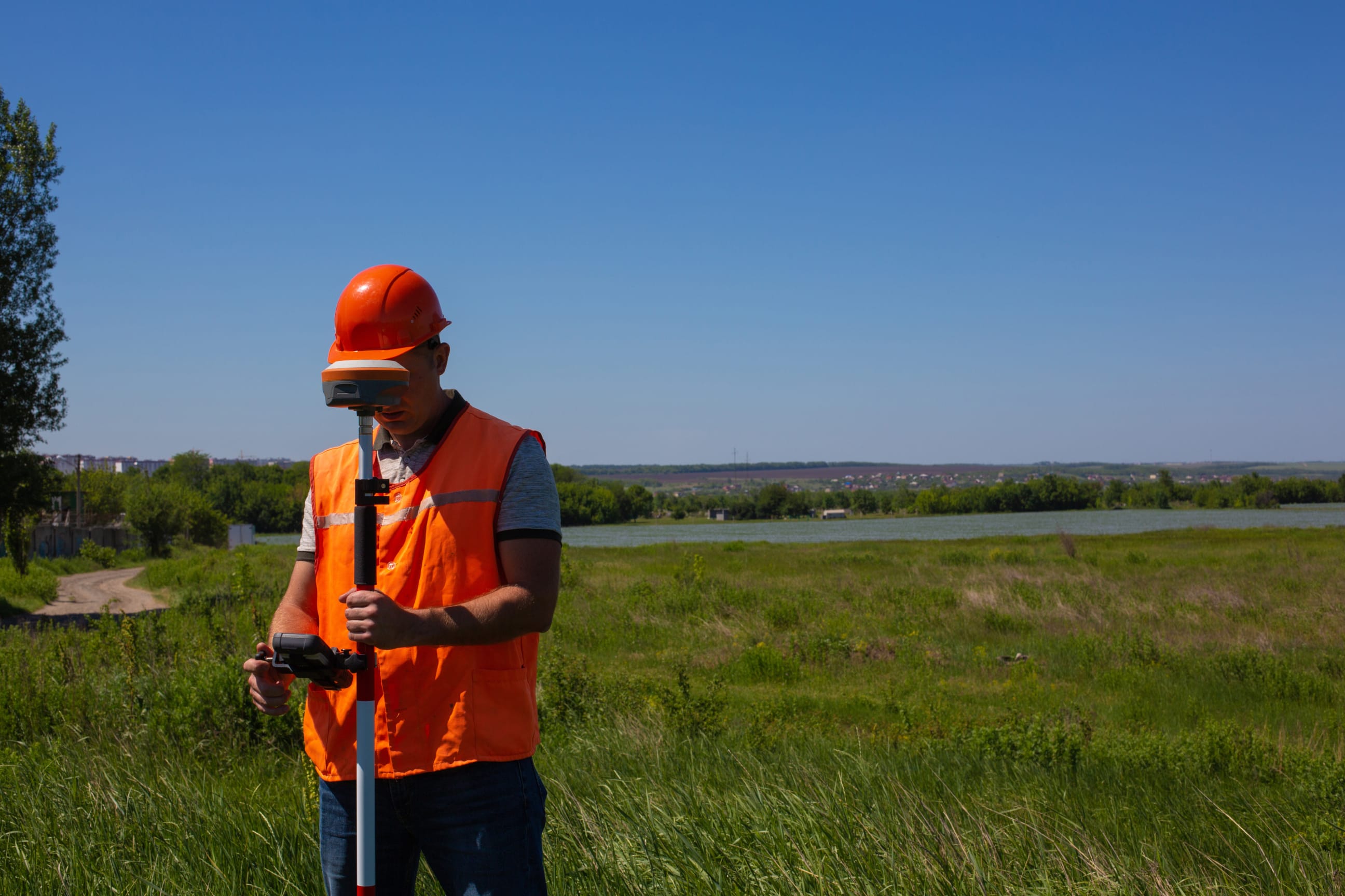 Professional male land surveyor measures ground control point using a gps rover.