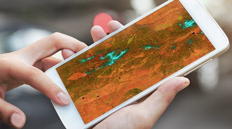 Due mani che utilizzano un grosso smartphone con una mappa 