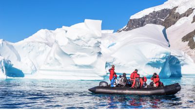 Um grupo de pessoas viajando em uma lancha observando icebergs